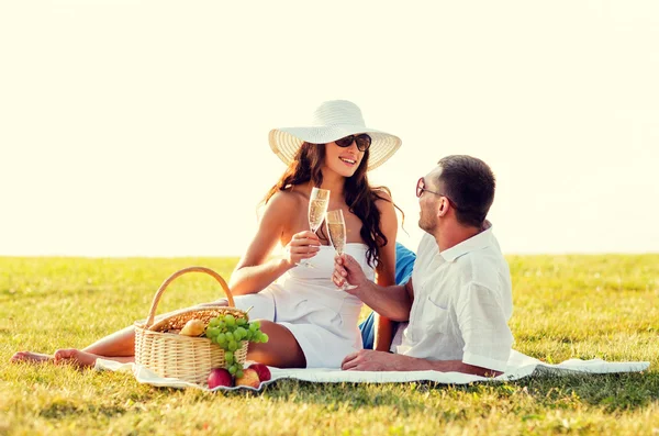 Улыбающаяся пара пьет шампанское на пикнике — стоковое фото