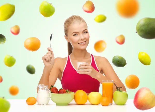Kvinnan äter yoghurt och med hälsosam frukost — Stockfoto