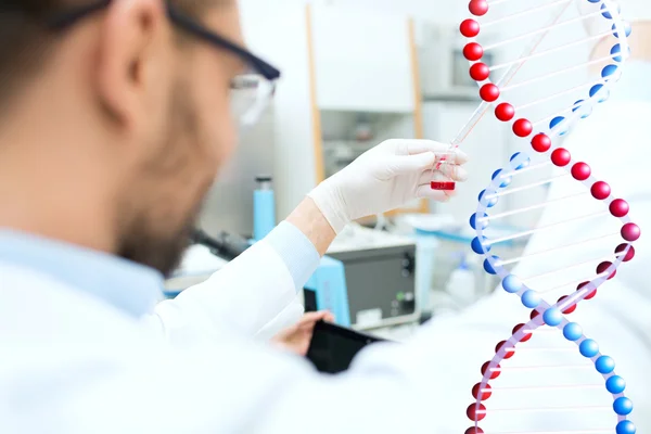 Primer plano de científico con tubo y pipeta en laboratorio — Foto de Stock