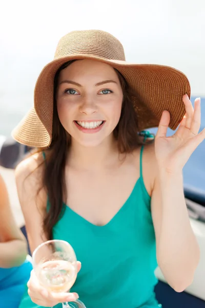 Lachende meisje in hoed met champagne glas — Stockfoto
