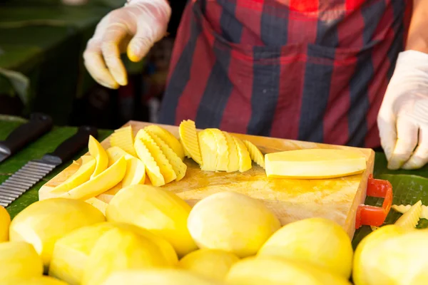 Primer plano de manos de cocinero y mango en el mercado callejero —  Fotos de Stock