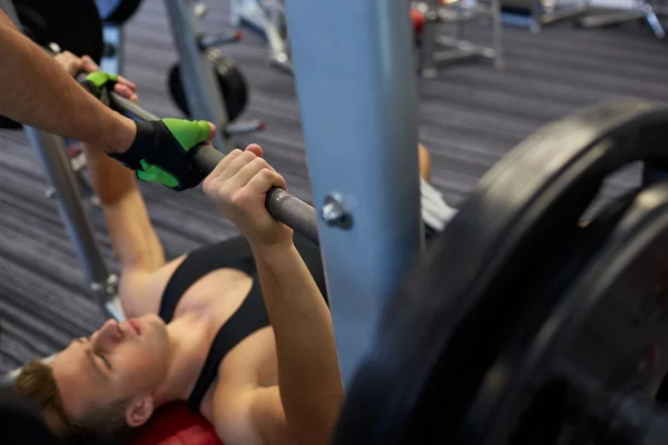 Dos hombres jóvenes con los músculos de flexión de la barra en el gimnasio — Foto de Stock