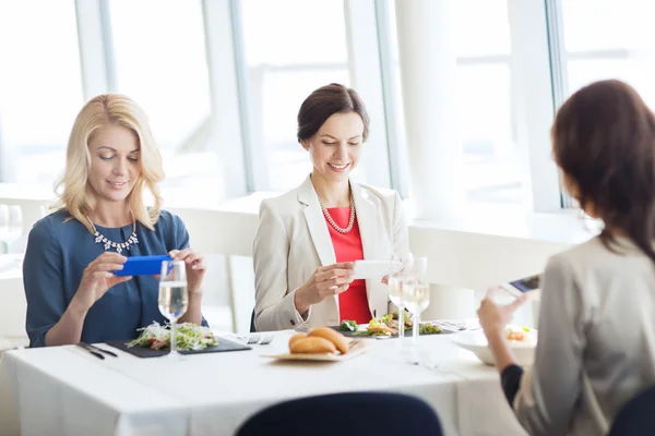 Mujeres con smartphones tomando fotos de comida —  Fotos de Stock