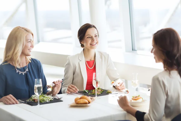 Femmes heureuses manger et parler au restaurant — Photo