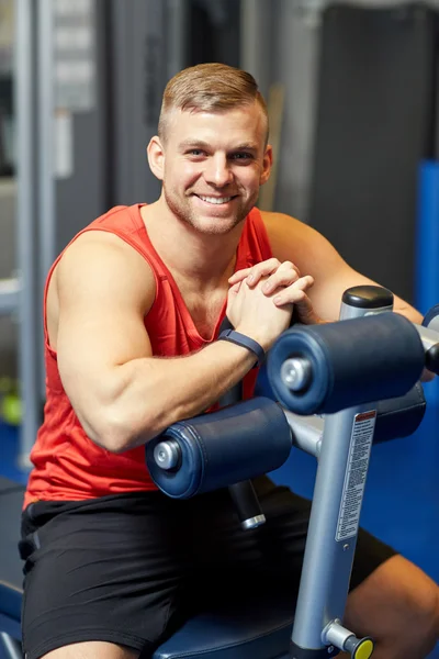 在健身房锻炼长椅上坐着的男人微笑着 — 图库照片