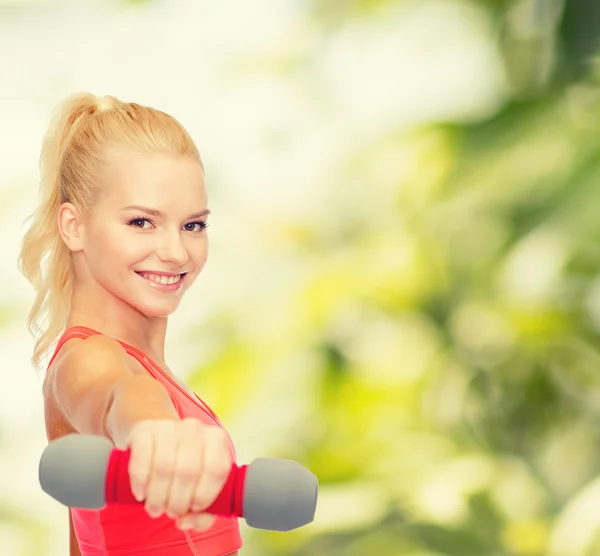 Smiling beautiful sporty woman with dumbbell — Stock Photo, Image