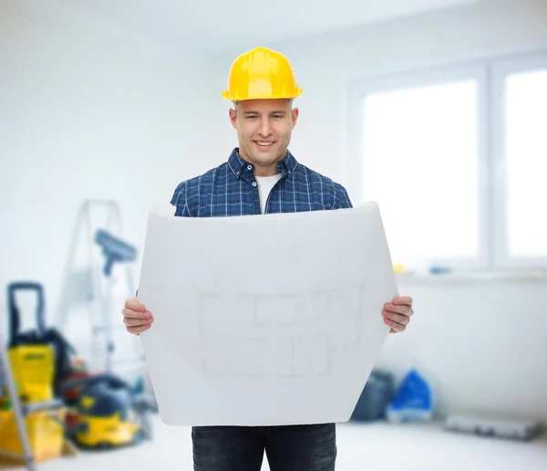 Smiling male builder in helmet with blueprint — Stock Photo, Image