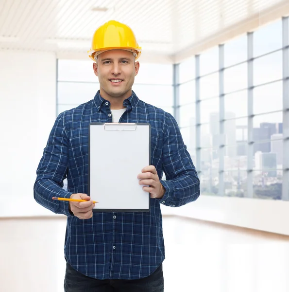 Costruttore maschio sorridente in casco con appunti — Foto Stock