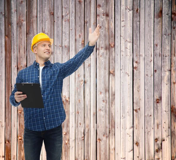 Sorridente construtor masculino no capacete com prancheta — Fotografia de Stock