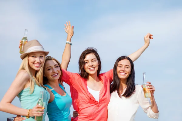 Meisjes met dranken op het strand — Stockfoto