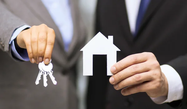 Businessman and businesswoman holding white house — Stock Photo, Image