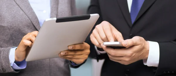 two businesspeople with smartphone and tablet pc