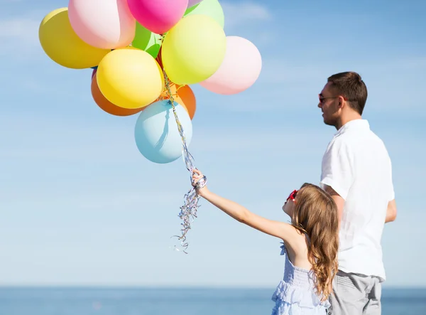 Far och dotter med färgglada ballonger — Stockfoto