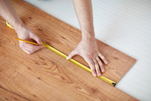 Close up of male hands measuring flooring — Stock Photo, Image