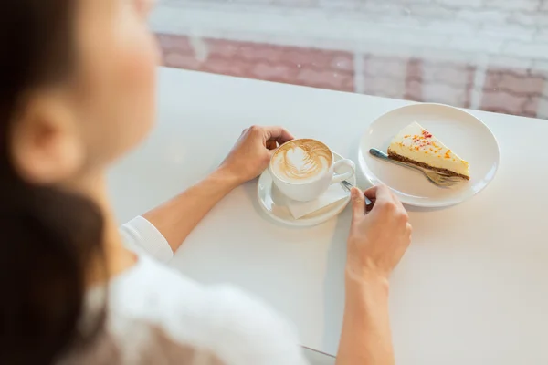 Крупним планом жіночі руки з тортами та кавою — стокове фото