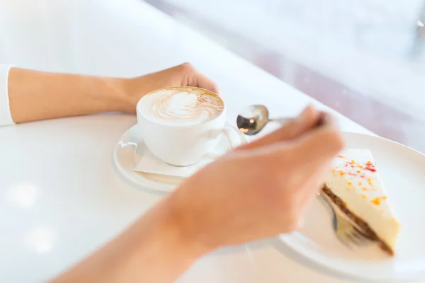 Close up de mãos de mulher com bolo e café — Fotografia de Stock