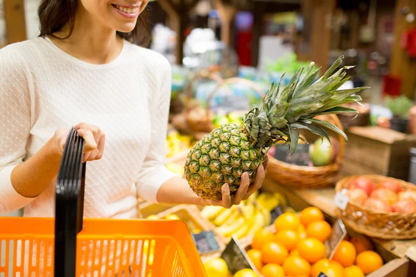 Close up of woman with pineapple in grocery market — Stock Photo, Image