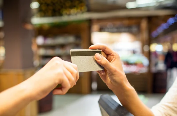Primer plano de las manos dando tarjeta de crédito en el centro comercial — Foto de Stock
