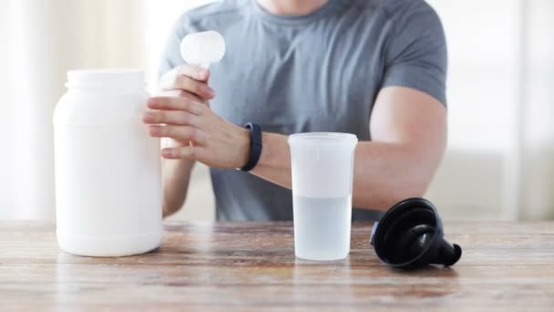 Close up of man with protein shake bottle and jar — Stock Video