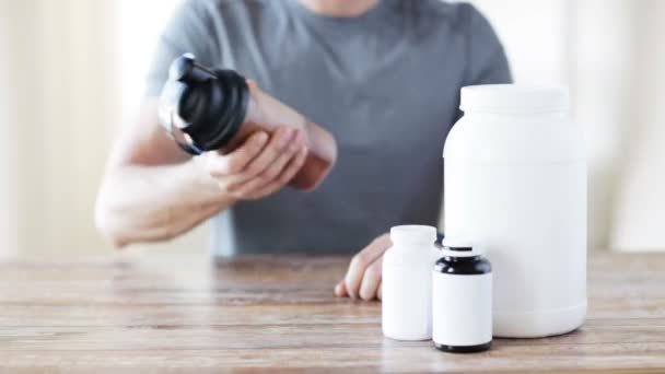 Close up of man with protein shake bottle and jars — Stock Video