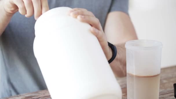 Nahaufnahme eines Mannes mit Protein-Shake-Flasche und Glas — Stockvideo