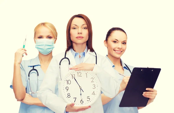 Calmo médico feminino e enfermeiros com relógio de parede — Fotografia de Stock