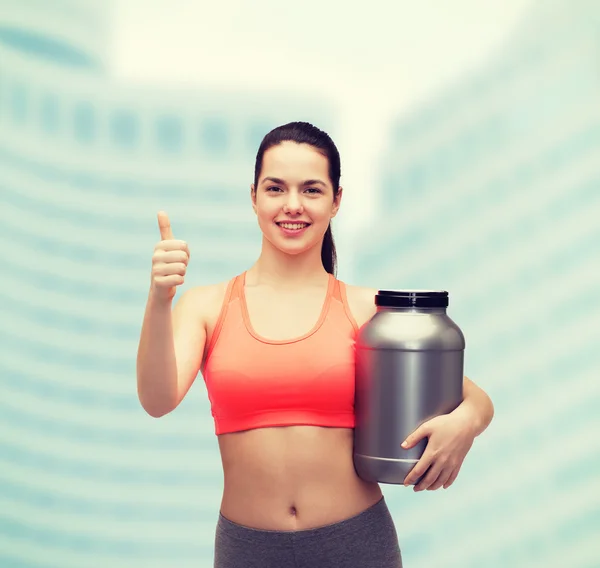 Adolescente con tarro de proteína mostrando los pulgares hacia arriba — Foto de Stock