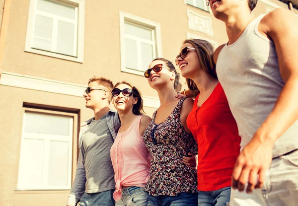 Grupp leende vänner gå i staden — Stockfoto