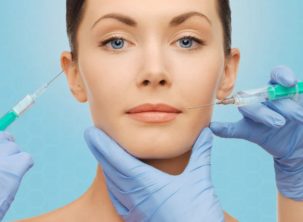 Kobieta twarzy i chirurga ręce ze strzykawki — Zdjęcie stockowe