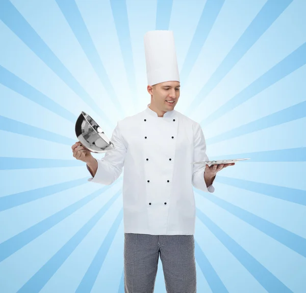 Happy male chef cook opening cloche — Stock Photo, Image