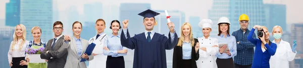 Feliz soltero con diploma sobre profesionales —  Fotos de Stock