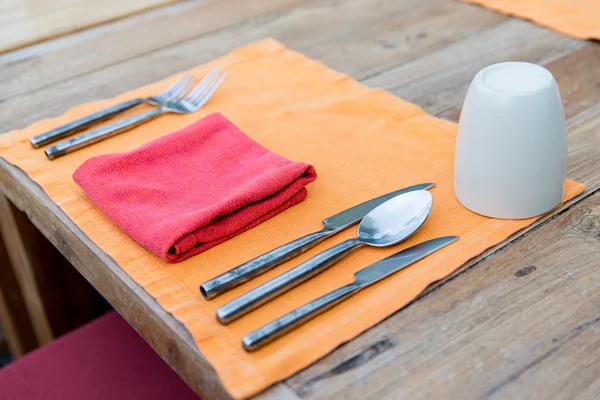 Close up of cutlery with glass and napkin on table — Stock Photo, Image