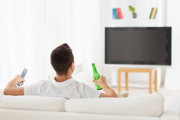 Άνθρωπος, βλέποντας τηλεόραση και πίνοντας μπύρα στο σπίτι — Φωτογραφία Αρχείου