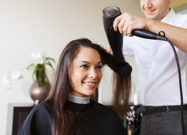 Szczęśliwa kobieta ze stylistką robi fryzurę w salonie — Zdjęcie stockowe