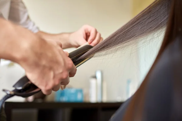 Estilista con plancha alisar el cabello en el salón — Foto de Stock