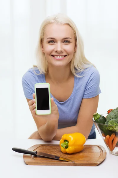 Lächelnde Frau mit Smartphone beim Gemüsekochen — Stockfoto