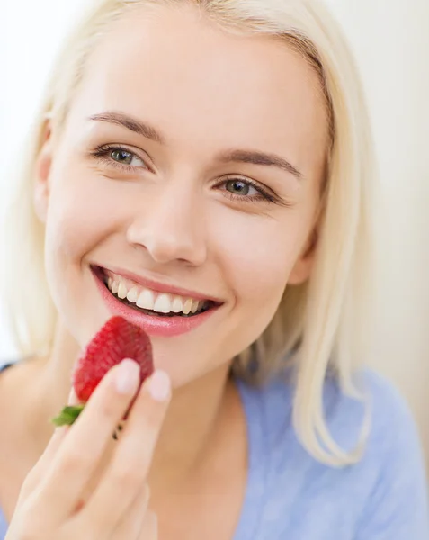 家でイチゴを食べる幸せな女 — ストック写真