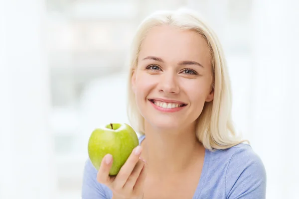 青リンゴを家で食べる幸せな女 — ストック写真
