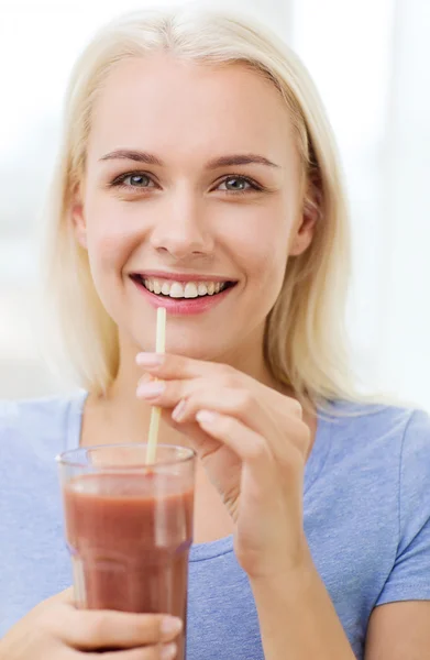 Usmívající se žena pití šťávy nebo koktejl doma — Stock fotografie