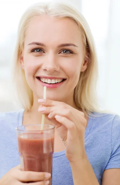 Donna sorridente bere succo o scuotere a casa — Foto Stock