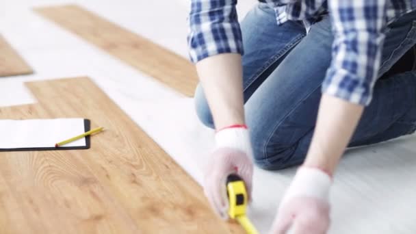 Close up of man measuring flooring and writing — Stock Video