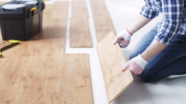 Close up of man installing wood floor — стоковое видео