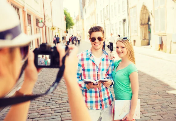 Uśmiechnięta para z mapy i aparatu fotograficznego w mieście — Zdjęcie stockowe