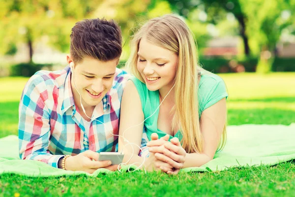 Casal sorridente com smartphone e fones de ouvido — Fotografia de Stock