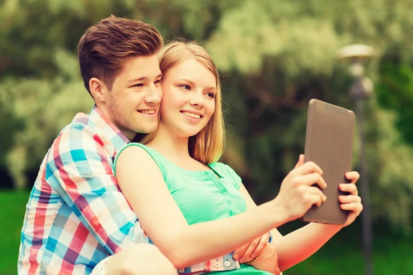 Smiling couple with tablet pc making selfie — Stock Photo, Image