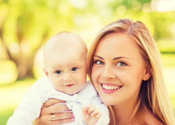 Närbild på glad mamma med lilla baby i park — Stockfoto