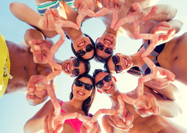 Усміхнені друзі в колі на літньому пляжі — стокове фото
