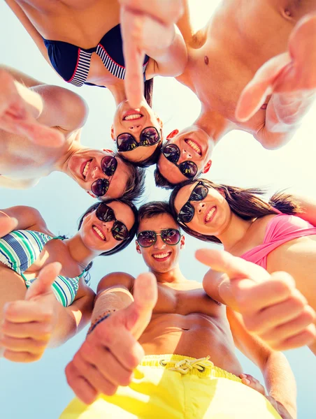 Smiling friends showing thumbs up in circle — Stock Photo, Image