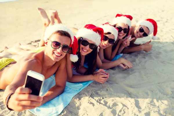 群在圣诞老人的帽子，与智能手机的朋友 — 图库照片