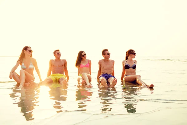 Amici sorridenti in occhiali da sole sulla spiaggia estiva — Foto Stock